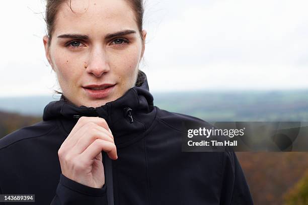 close up of woman zipping up coat - zipper stock pictures, royalty-free photos & images