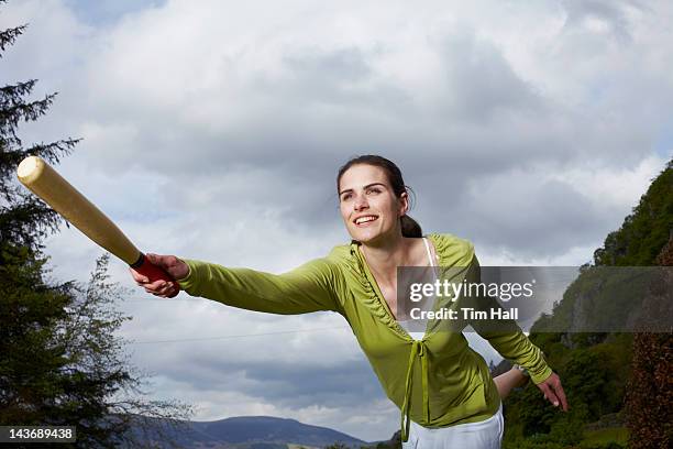 woman playing with bat in rural field - baseball hall stock pictures, royalty-free photos & images