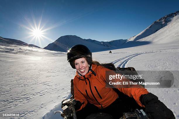 frau mit dem schneemobil fahren im schnee field - snowmobiling stock-fotos und bilder