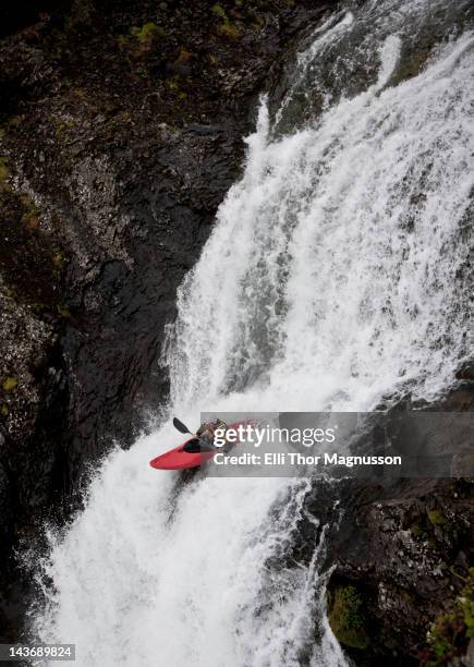 man canoeing over rocky waterfall - stroomversnelling stockfoto's en -beelden