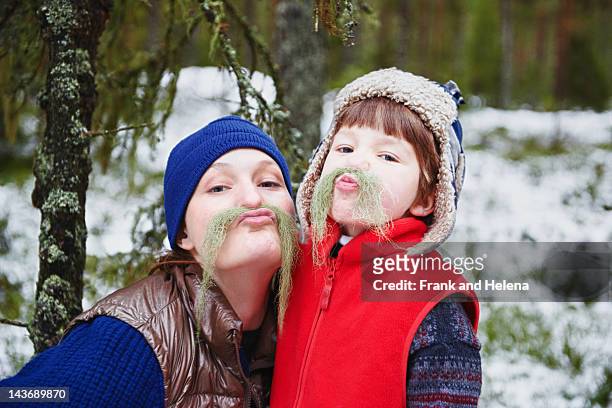 mother and son playing with moss - sverige vinter bildbanksfoton och bilder