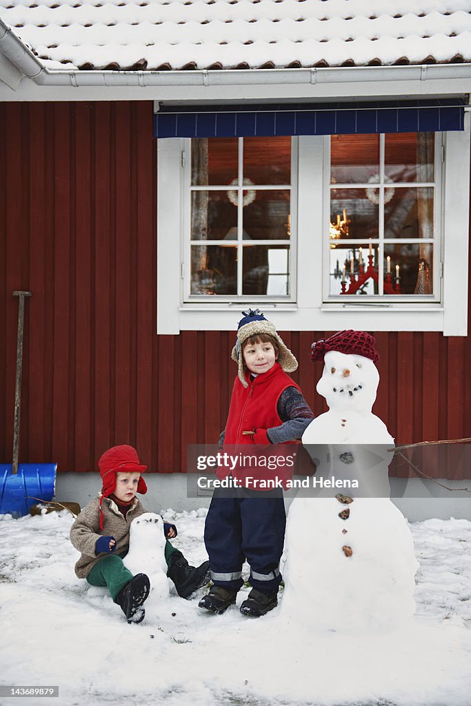 Boys making snowmen together