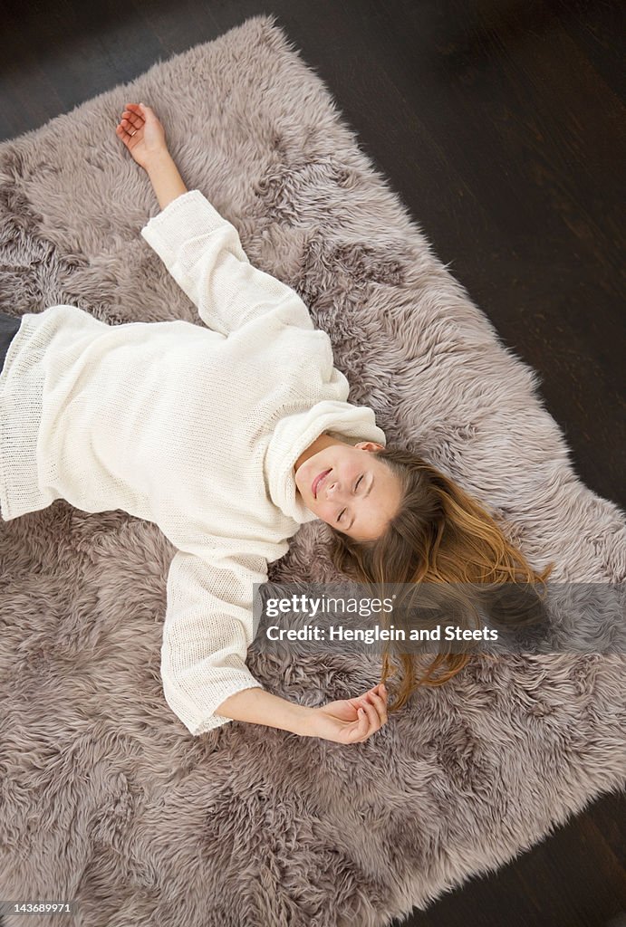 Smiling woman laying on rug