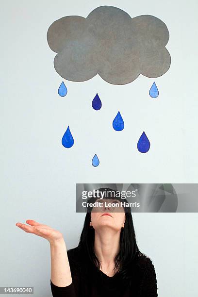 woman standing under painted rain cloud - pessimisme stock pictures, royalty-free photos & images