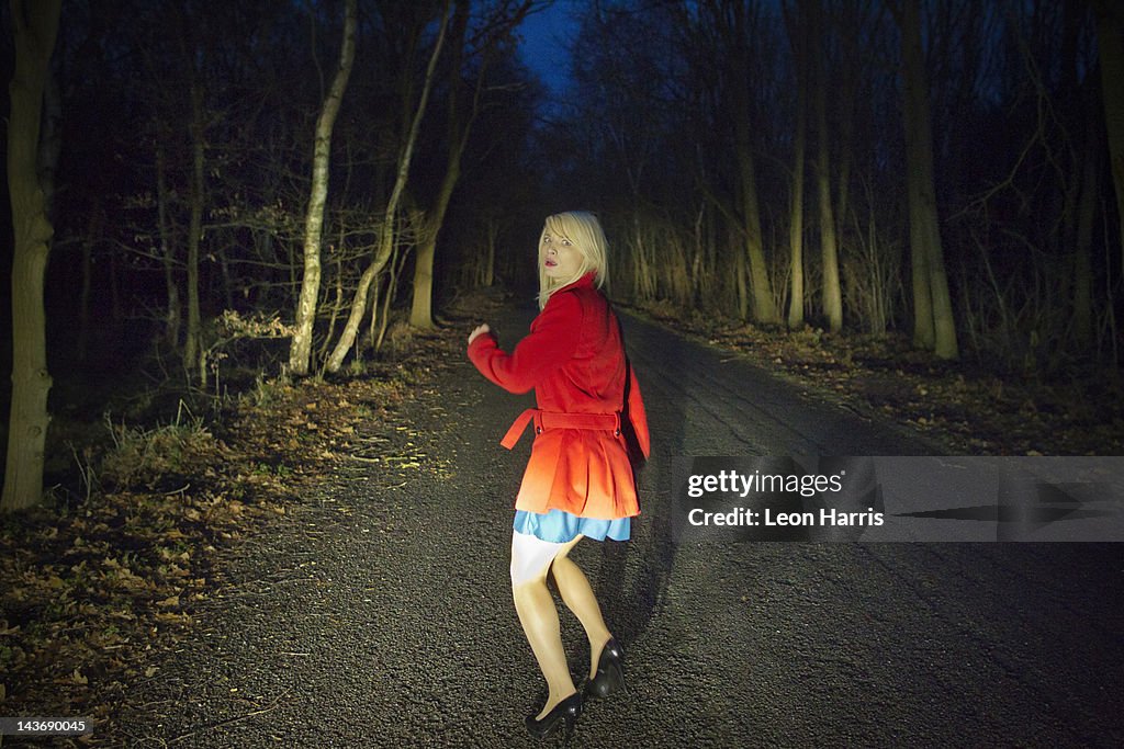 Woman running in fear in woods at night