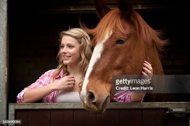 teenager-mädchen mit pferd in stables - pferdestall stock-fotos und bilder