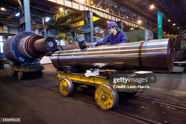 trabajador limpieza de metal en acero forge - siderurgicas fotografías e imágenes de stock