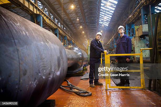 operai parlano in acciaio forgiato - worker inspecting steel foto e immagini stock