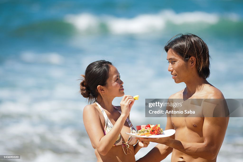 Couple eating together on beach