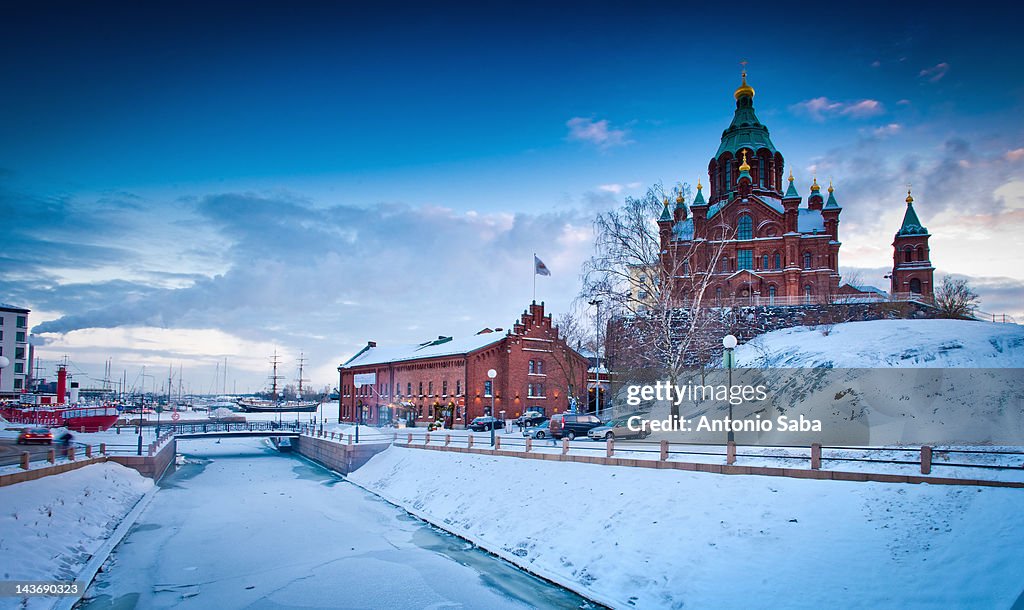 Snow-covered castle by frozen river