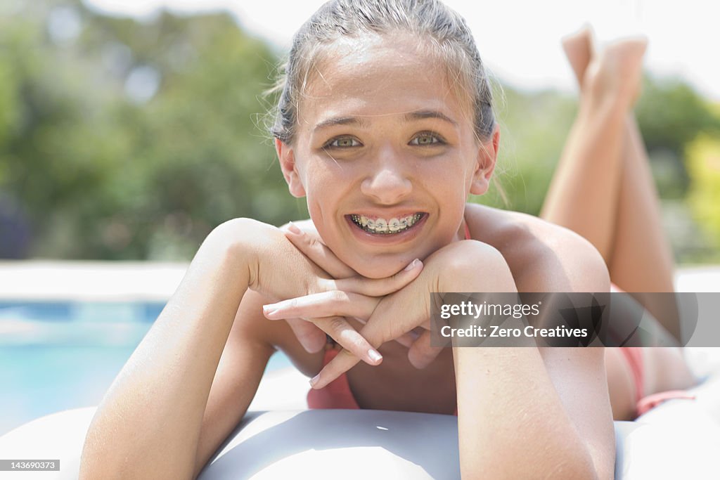 Teenage girl in braces relaxing by pool
