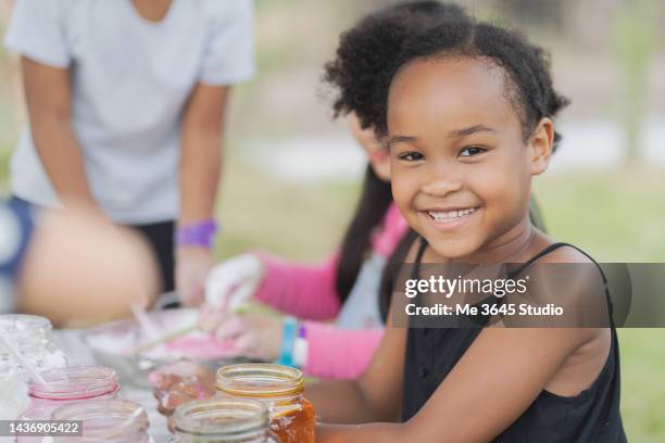 take a photo of a cute girl looking at the camera smiling. - 4 girls finger painting bildbanksfoton och bilder