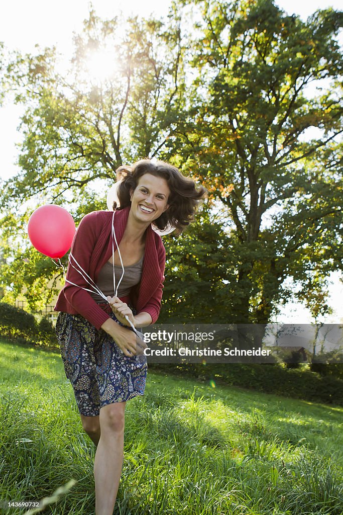 Smiling woman carrying balloons
