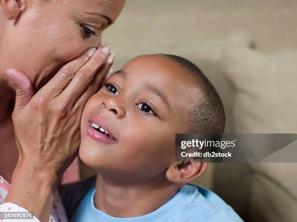 close up of mother whispering to son - child whispering stockfoto's en -beelden