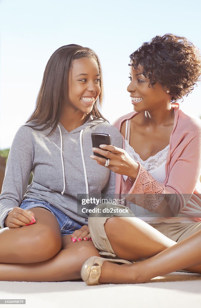 Mother and daughter using cell phone