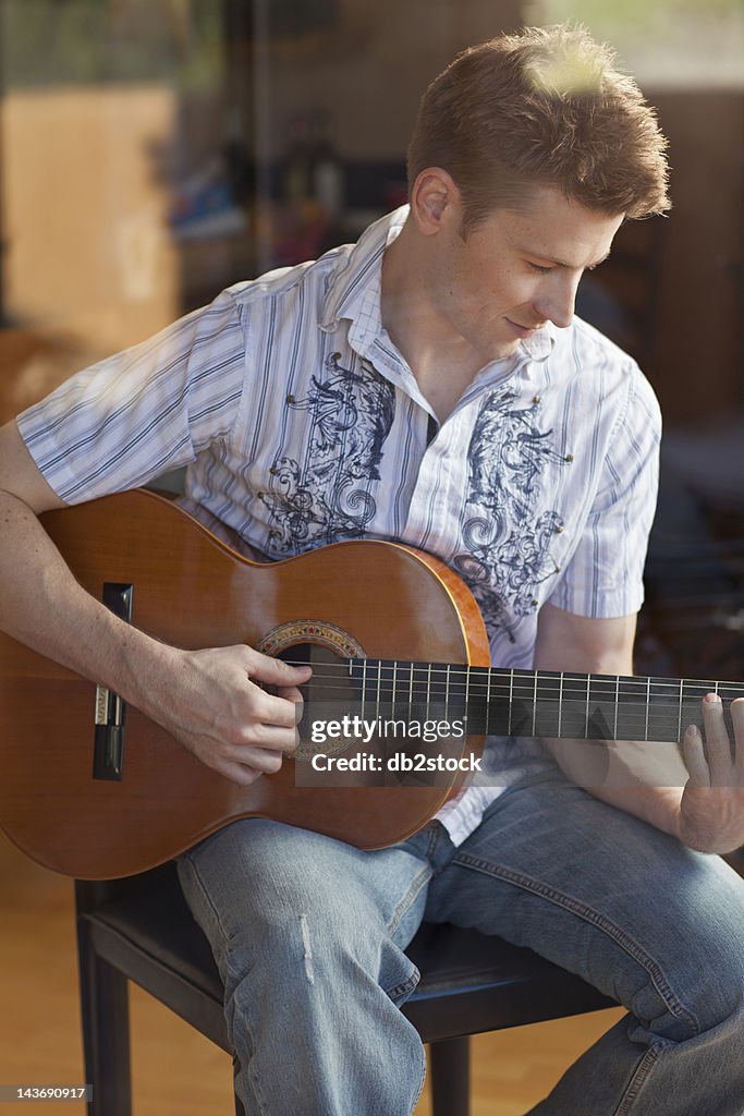 Man playing guitar in living room