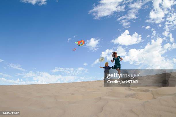 mother and son flying kite on beach - fuerteventura beach stock pictures, royalty-free photos & images