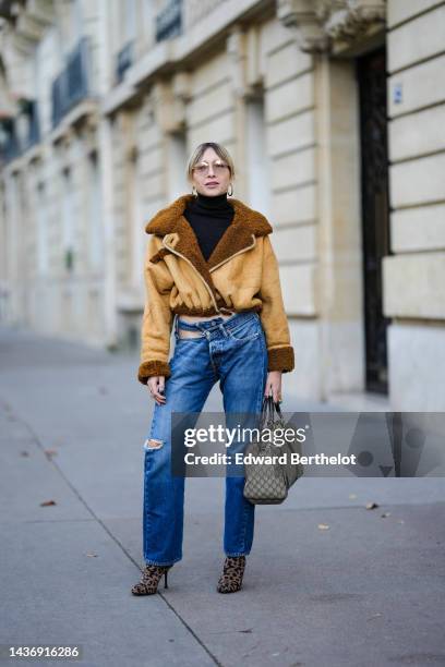 Emy Venturini wears a black ribbed wool turtleneck pullover, a yellow suede and brown sheep interior aviator coat from She Abbigliamento, blue...