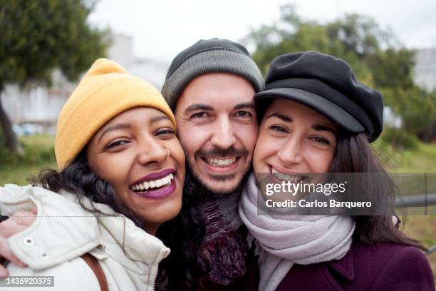 close up of three friends from different countries looking at camera happily. - leeftijdsverschil stockfoto's en -beelden