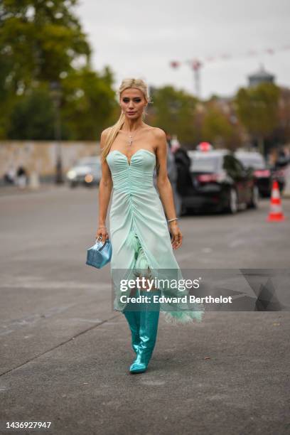 Guest wears silver and diamonds pendant necklaces, a mint green wrap / heart neck / shoulder-off / long slit dress with embroidered feathers borders,...