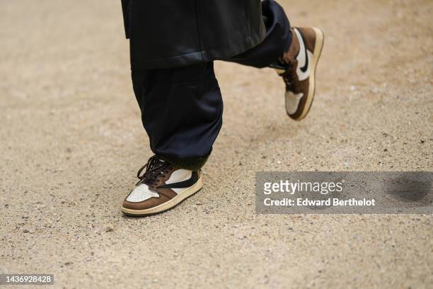 Guest wears black large puffy pants, white latte leather and brown suede ankle boots from Nike , outside Zimmermann, Paris Fashion Week - Womenswear...