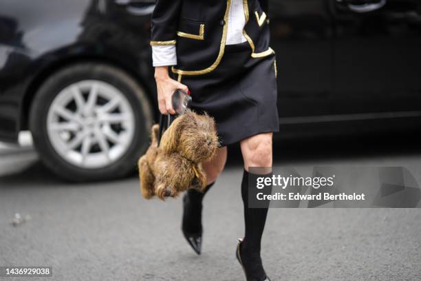 Guest wears a black with embroidered gold borders jacket, a black short skirt, black socks, black shiny varnished leather pointed pumps heels shoes,...