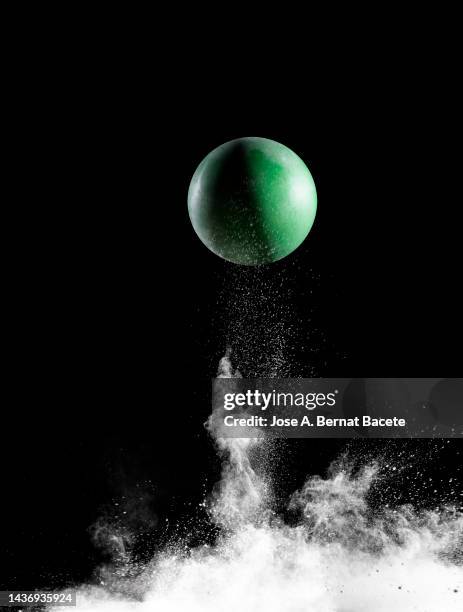 impact and rebound of a toy ball on a surface of land and powder on a black background - ballon rebond stock pictures, royalty-free photos & images