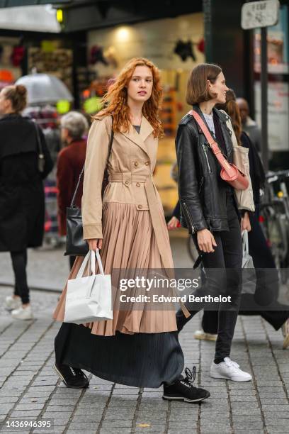 Guest wears a gray t-shirt, a beige belted / accordion long coat, a dark gray silk long skirt, a black shiny leather shoulder bag, black suede...