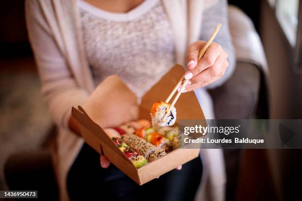 woman enjoying takeaway food at home - making sushi stock pictures, royalty-free photos & images