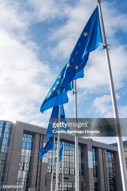 european union flags in front of european council building - council of europe stock-fotos und bilder