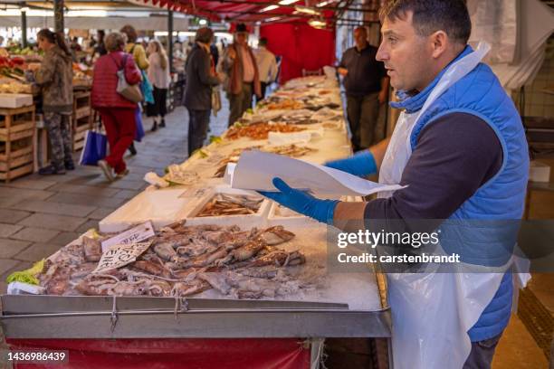 pescheria che vende calamari - pescivendolo foto e immagini stock