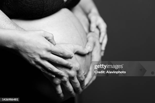 unrecognizable pregnant couple close up studio shot - family studio shot stock pictures, royalty-free photos & images