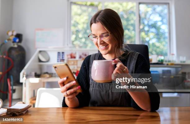 telefono, caffè e social media con una donna freelance che si prende una pausa mentre fa ricerca per il design. creativo, proprietario di una piccola impresa e comunicazione con l'imprenditrice in una startup da casa - marcare foto e immagini stock