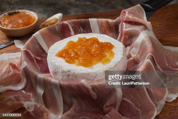 preparing  prosciutto wrapped brie - aprikossylt bildbanksfoton och bilder