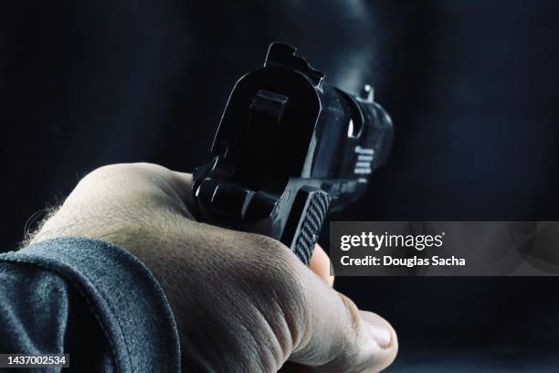 pointing a loaded gun - pistool handwapen stockfoto's en -beelden