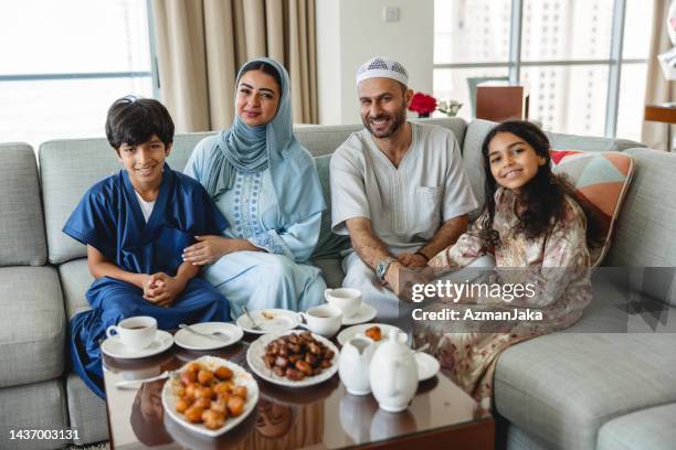 young middle eastern parents with their children in the living room - middle eastern food stockfoto's en -beelden