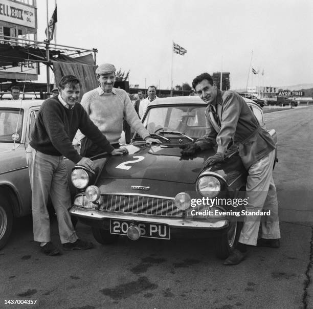 Racing drivers Bruce McLaren , Graham Hill and Roy Salvadori celebrating the 20th anniversary of the Ford Anglia car at Goodwood Racecourse in Sussex...