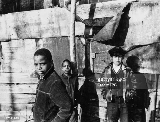 Group of boys hanging out together, United States, circa 1980. One of the boys wears a corduroy jacket, while a boy in the background wears a striped...