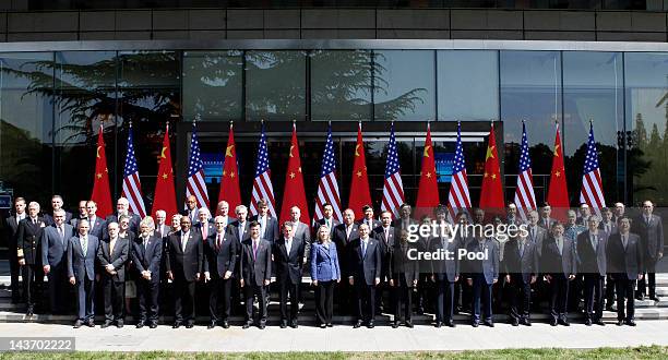 Chinese and American participants of the U.S.-China Strategic and Economic Dialogue pose for a group photo in front of Chinese and American national...