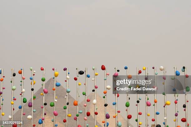 People view the installation "Dreams in Giza" by Cameroonian artist Pascale Marthine Tayou at the Giza pyramids necropolis during the second edition...