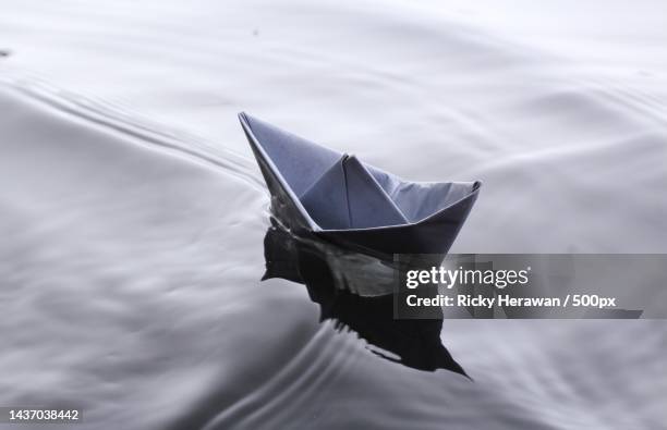 high angle view of paper boat floating on water - toy boat stock pictures, royalty-free photos & images