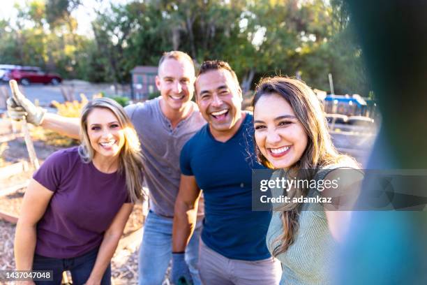 volunteer friends gardening at sunset taking a selfie - victory parish stock pictures, royalty-free photos & images