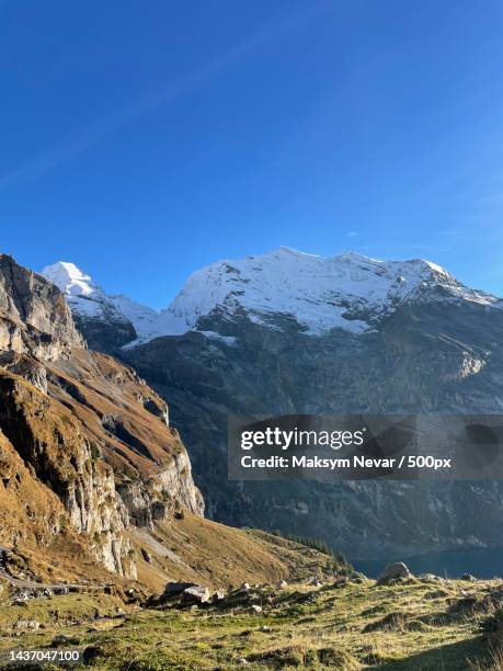 scenic view of snowcapped mountains against clear blue sky,oeschinen lake,kandersteg,switzerland - nevar foto e immagini stock