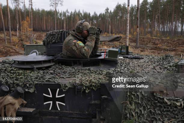 Tank commander looks through binoculars on a Leopard 2A6 main battle tank of the Bundeswehr, the German armed forces, during the NATO Iron Wolf...