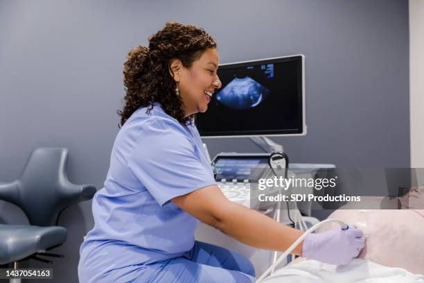 un técnico sonriente de ultrasonido habla con la madre - ecografista fotografías e imágenes de stock