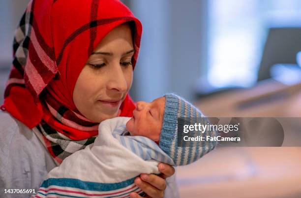 muslim mother looking at her new baby - pregnant muslim stockfoto's en -beelden