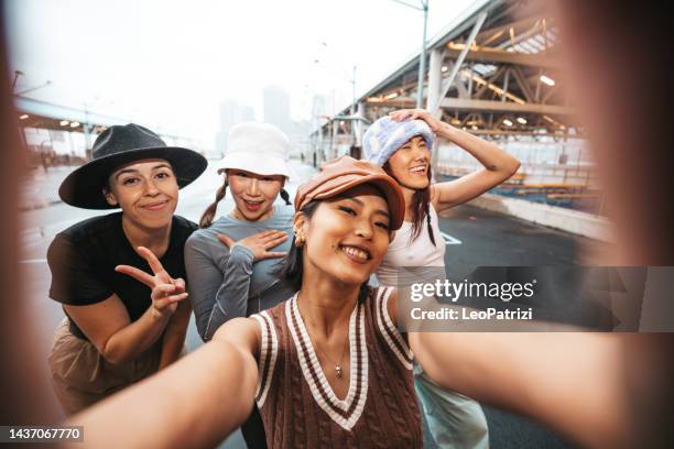 four female friends taking a selfie - street fashion asian stock pictures, royalty-free photos & images