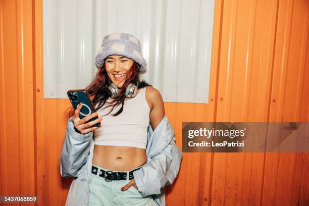 woman texting on mobile out of a club at saturday night - phone street style stock pictures, royalty-free photos & images