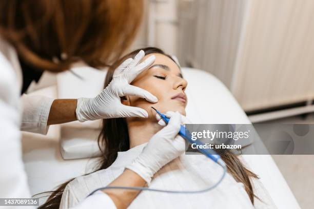 une jeune femme reçoit un traitement de beauté pour les points noirs dans une clinique médicale - blackheads photos et images de collection