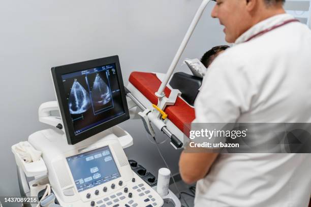 young man having an abdominal ultrasound at the medical clinic - echoscopist stockfoto's en -beelden